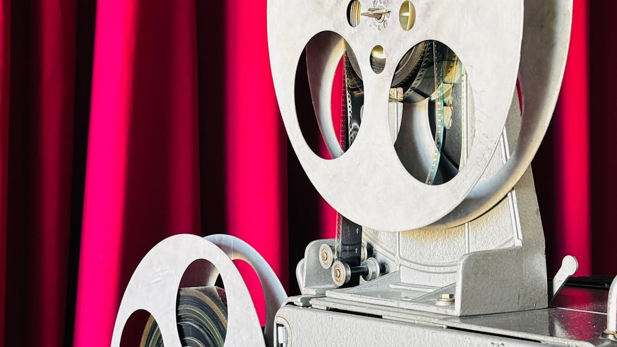 Alter Filmprojektor vor rotem Vorhang, Symbol des klassischen russischen Kinos