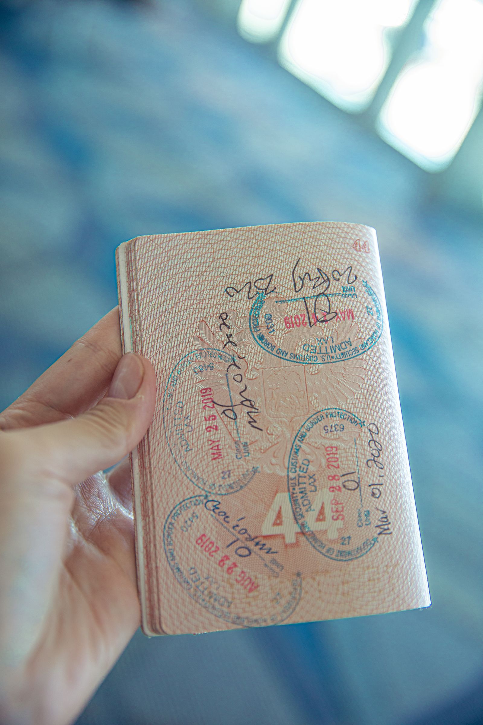 Hand hält einen aufgeschlagenen Reisepass mit Stempeln, wie bei der Passkontrolle bei der Einreise nach Russland